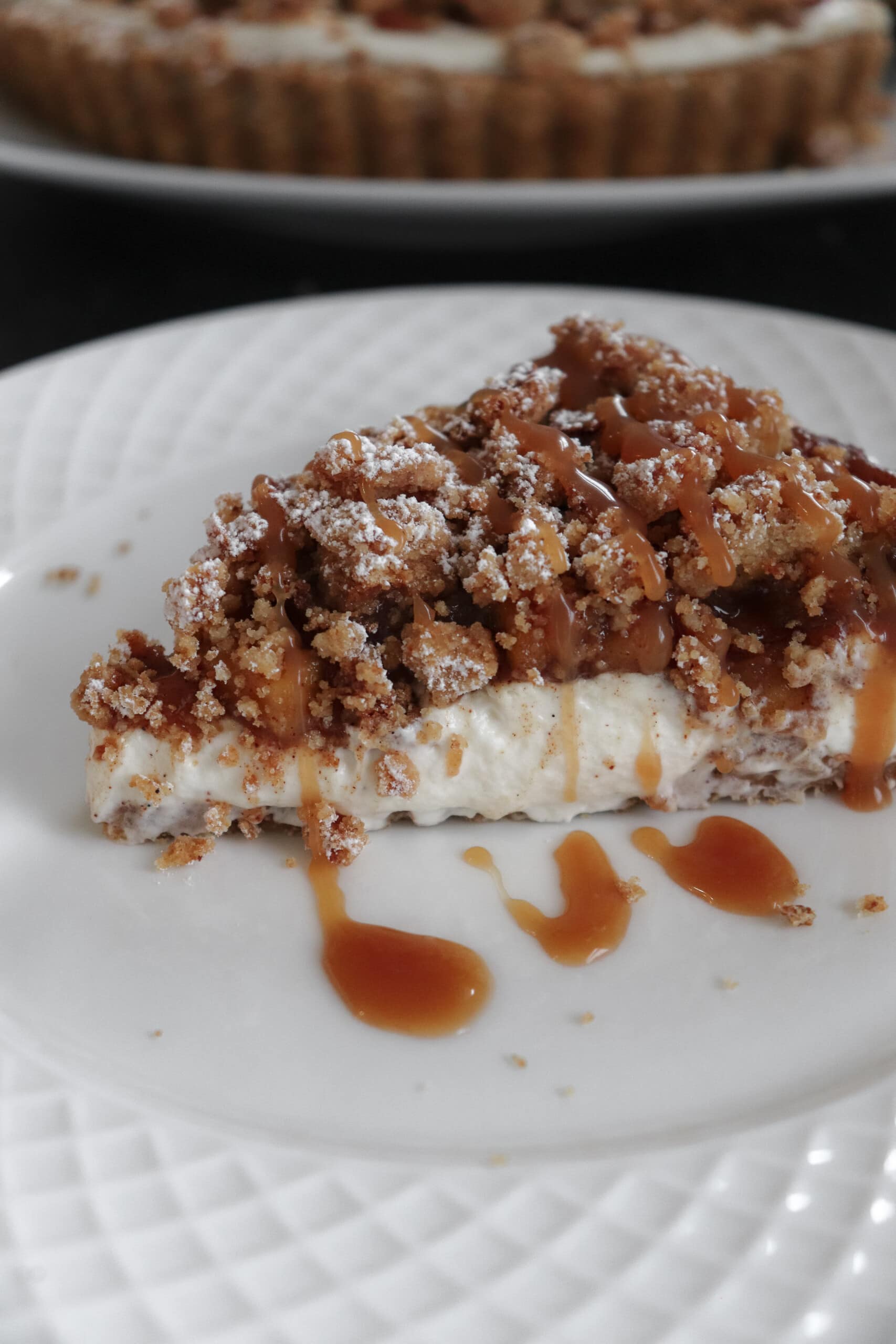 apple crumble pie with caramel sauce drizzle on plate